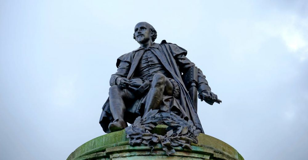 Shakespeare - Statue of William Shakespeare in Stratford-upon-Avon, England against a cloudy sky.