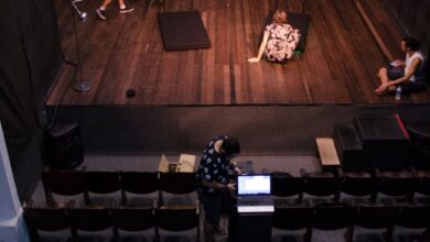 Theater - Actors rehearsing on stage in an empty theater, viewed from above.