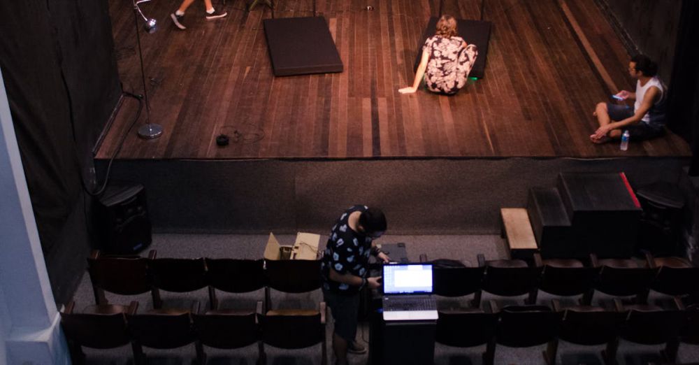 Theater - Actors rehearsing on stage in an empty theater, viewed from above.