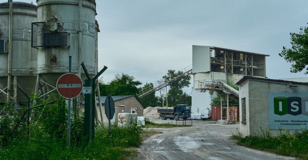 Productions - Industrial landscape with cement silos and equipment outdoors.