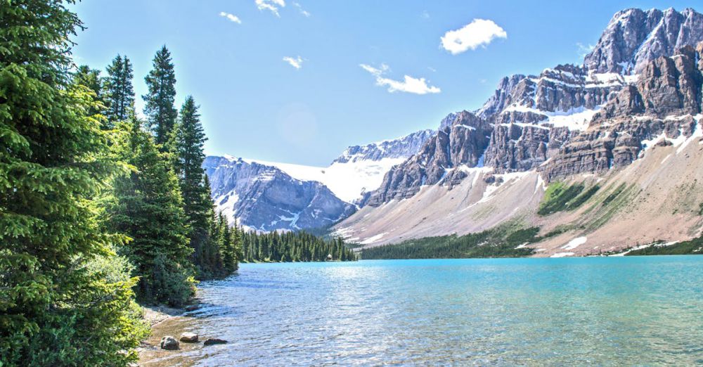 Places - Stunning view of Bow Lake with rocky mountains and green forests in Banff National Park.