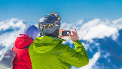 Tours - Two skiers capturing the breathtaking mountain views on a snowy winter day.