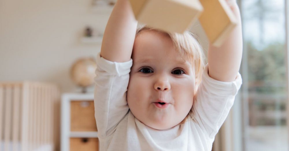 Toddlers - Adorable baby enjoying playtime with wooden blocks in a cozy indoor setting. Perfect depiction of joy and learning.