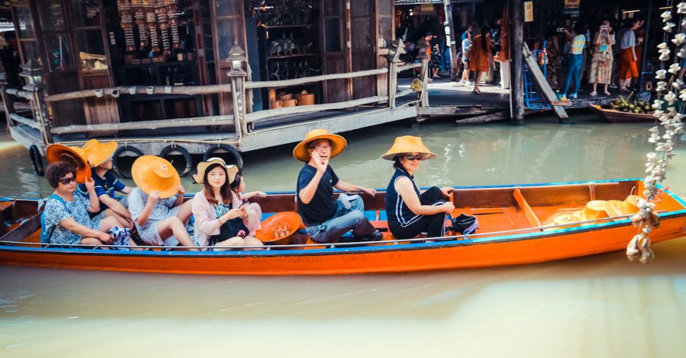 Tour - A group of tourists in a boat at a vibrant floating market in Thailand, exploring local culture.