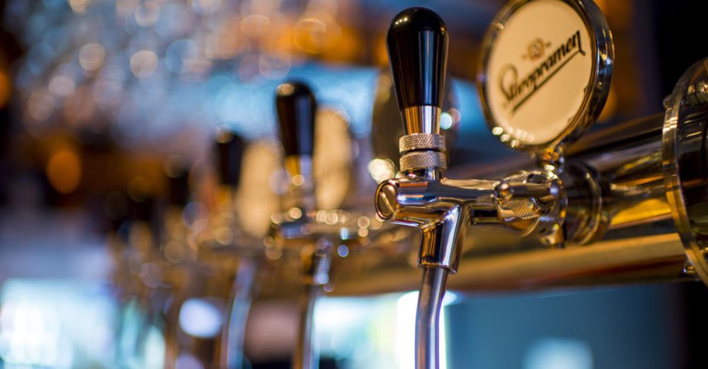 Pub - Focused image of a shiny beer tap in a stylish bar with a blurred background.