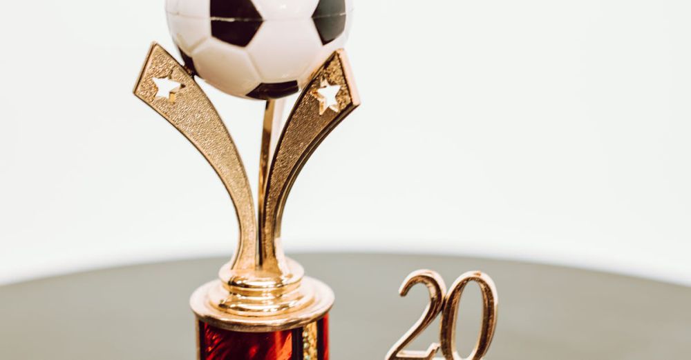 Sports Gifts - Shiny golden soccer trophy with ball and the year 20 on black surface.