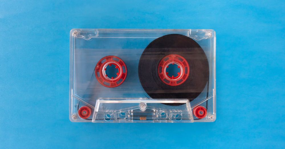 Guides - Vintage transparent cassette tape with red reels on a bright blue background.