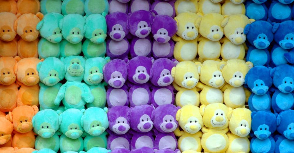 Stuffed Animals - Vibrant pastel teddy bears in a colorful pattern at a carnival game stall wall display.