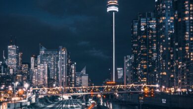 Locations - Stunning night view of Toronto skyline featuring the CN Tower and blurred train motion.