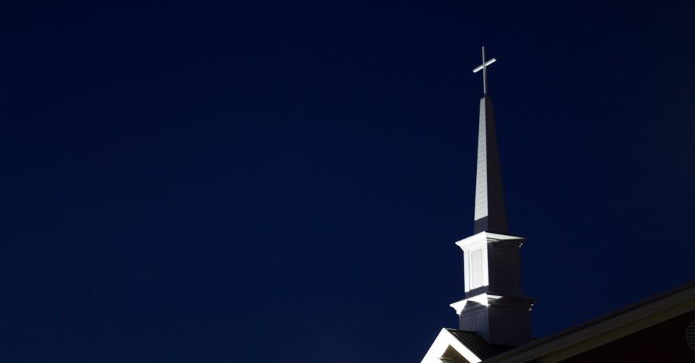 Guided - Illuminated church steeple with cross at night. Perfect for religious and architectural themes.