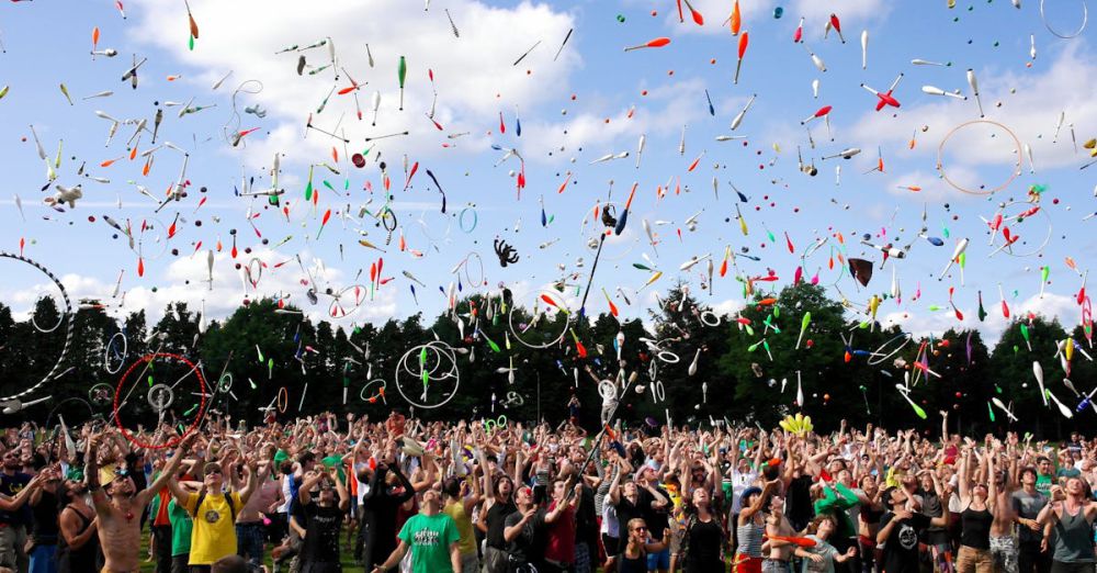 Festivals - A lively crowd enjoying a colorful juggling event outdoors. Perfect for summer festival themes.