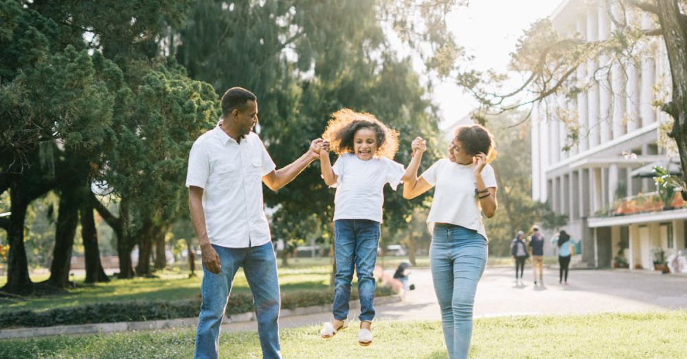 Families - Joyful family enjoying a playful day at the park, embracing love and togetherness under the summer sun.