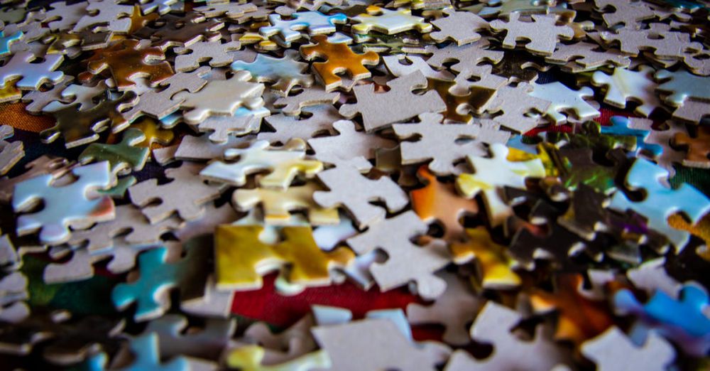 Puzzles - A colorful collection of jigsaw puzzle pieces scattered on a flat surface, ideal for hobby and leisure themes.