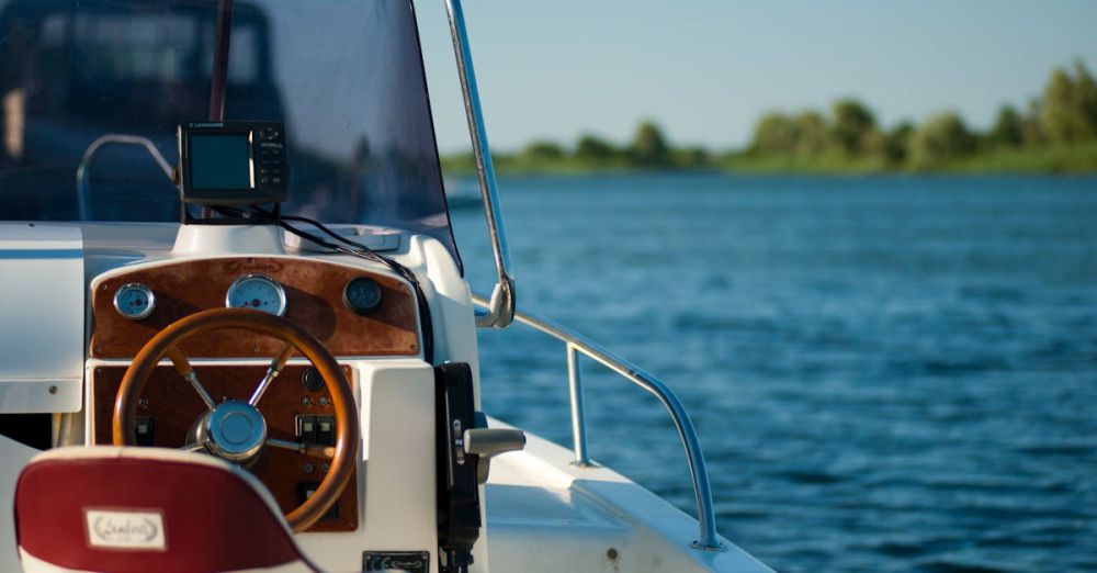 Boating - A yacht steering wheel with a serene water view during a bright summer day offering leisure and adventure.