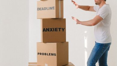 Subscription Boxes - A man in casual attire balances boxes labeled with stress-related words indoors.