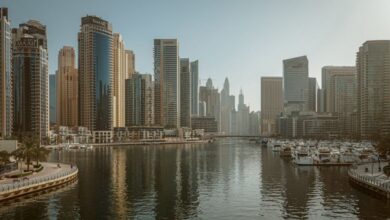 Marinas - Stunning view of Dubai Marina featuring skyscrapers and calm reflective waters under a clear sky.