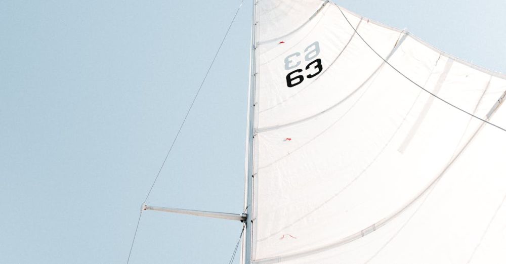 Sail - Minimalist view of a sailboat's mast and sails under a clear blue sky, creating a sense of adventure and freedom.