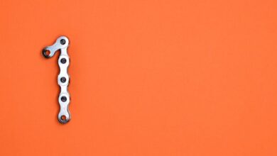 Gear - Metal chain forming the number one on an orange background, ideal for design concepts.