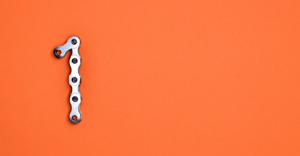 Gear - Metal chain forming the number one on an orange background, ideal for design concepts.