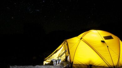 Tent - A glowing yellow tent pitched outdoors under a vast, star-filled night sky, capturing the essence of camping adventure.