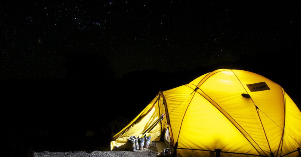 Tent - A glowing yellow tent pitched outdoors under a vast, star-filled night sky, capturing the essence of camping adventure.