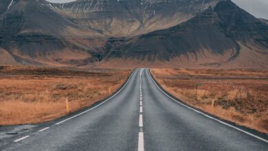 Adventure - A scenic empty road stretches into snow-capped mountains under cloudy skies, offering a sense of adventure and tranquility.