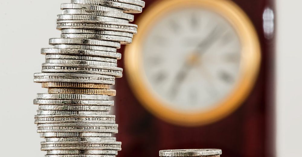 Budget - A close-up image of stacked coins with a blurred clock, symbolizing time and money relationship.