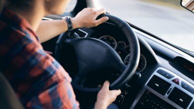 Drive - Close-up view of a man driving a modern car, showing dashboard and steering details.