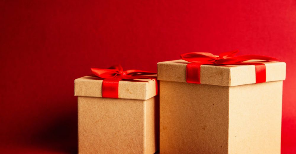 Gifts - Two gift boxes with red ribbons on a vibrant red background.