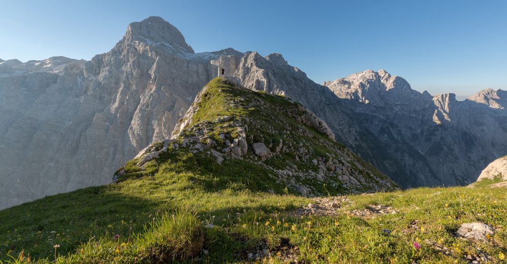 Expeditions - Experience the serene beauty of the Julian Alps, captured in daylight with lush green pastures and towering peaks.