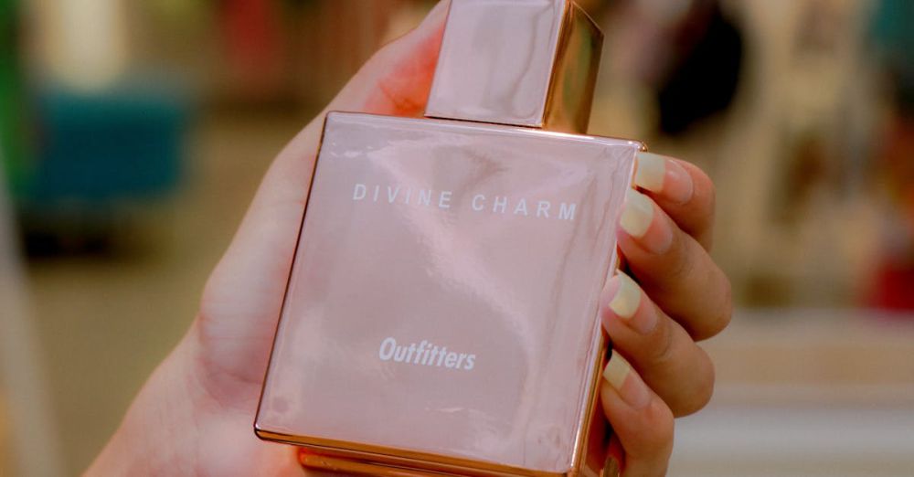 Outfitters - Elegant close-up shot of a perfume bottle held in hand with blurred background.