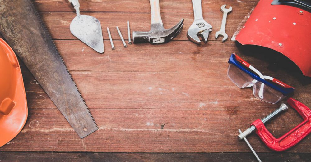 Safety - Flat lay of various workshop tools on a rustic wooden table, showcasing DIY essentials.