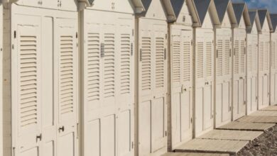 Cabins - A line of white beach huts under a clear blue sky, ideal for summer themes.