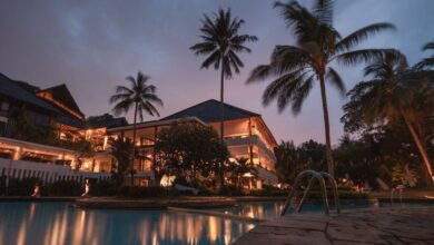 Resorts - Luxurious tropical resort with swimming pool and palms at dusk, perfect for a tranquil vacation.