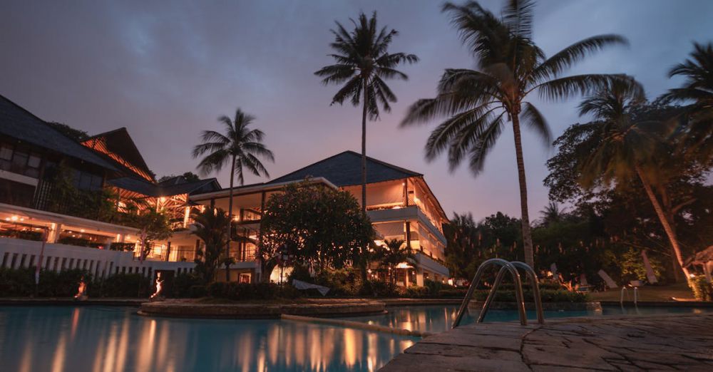 Resorts - Luxurious tropical resort with swimming pool and palms at dusk, perfect for a tranquil vacation.