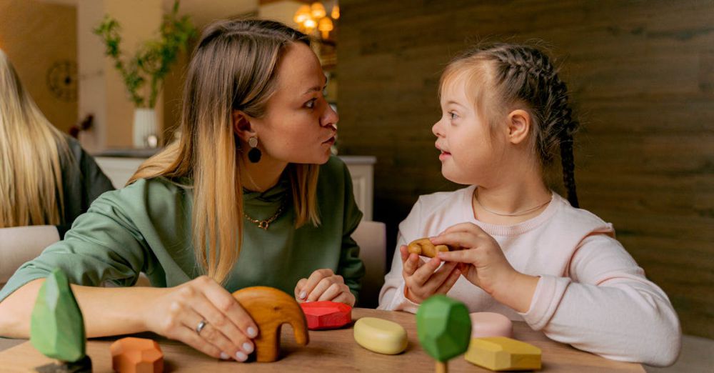 Special Needs - An adult woman and a child with Down syndrome engaging in playful interaction with wooden toys indoors.