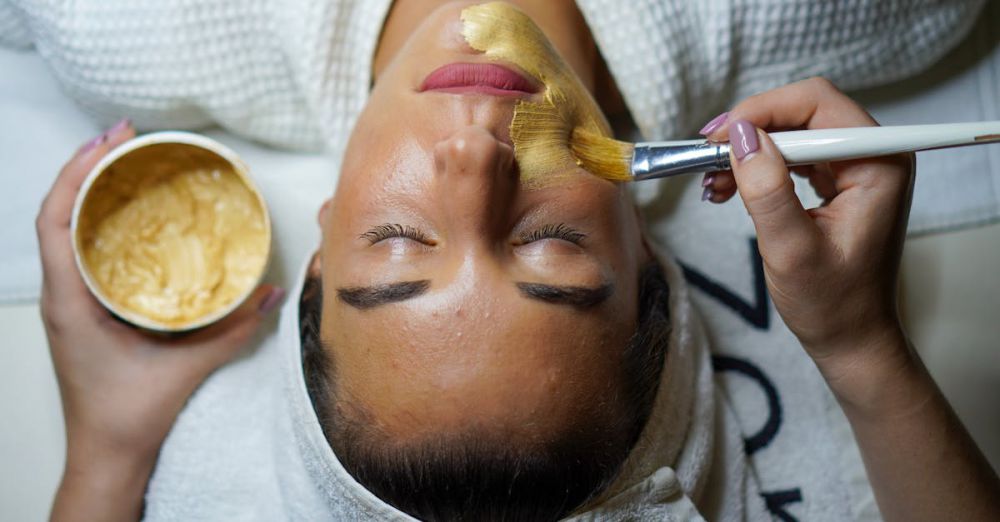 Spa - A woman enjoying a gold facial mask for relaxation and skincare at a spa.