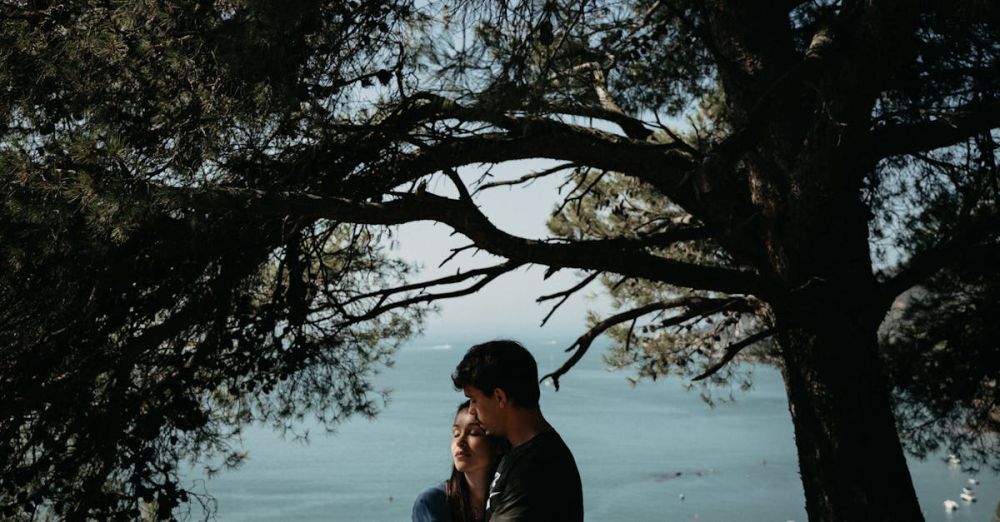 Romantic - A couple embracing under trees with a scenic ocean view, conveying love and tranquility.