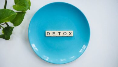 Detox - Minimalist concept of detox with letter tiles on a turquoise plate and green leaves.