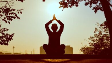 Yoga - Silhouette of a person practicing yoga outdoors during sunrise, creating a calming atmosphere.