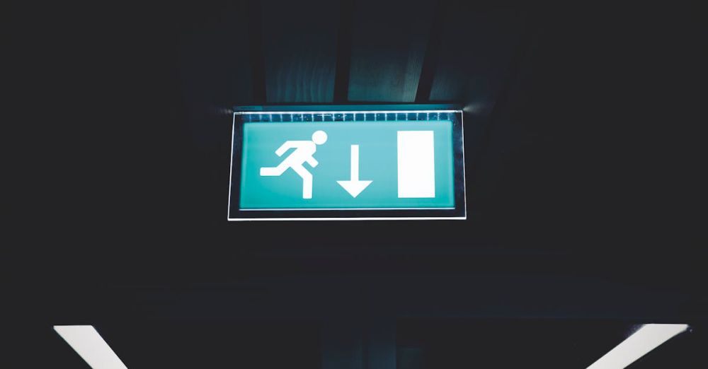 Escape - Brightly lit emergency exit sign with arrow indicating direction, set against a dark backdrop.