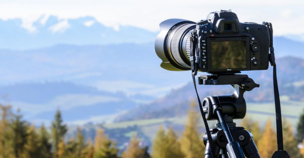 Photography - DSLR camera on tripod capturing a stunning mountain view on a clear day.