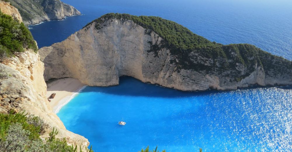 Beaches - A breathtaking view of Navagio Beach with azure waters surrounded by cliffs in Greece.