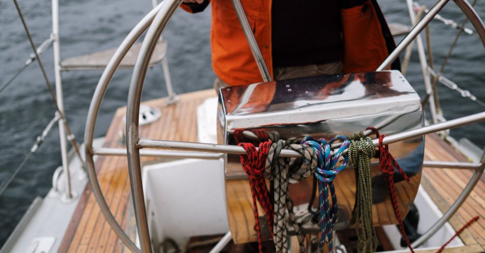 Boat - Close-up of a sailor holding the helm of a sailboat, navigating the open sea.