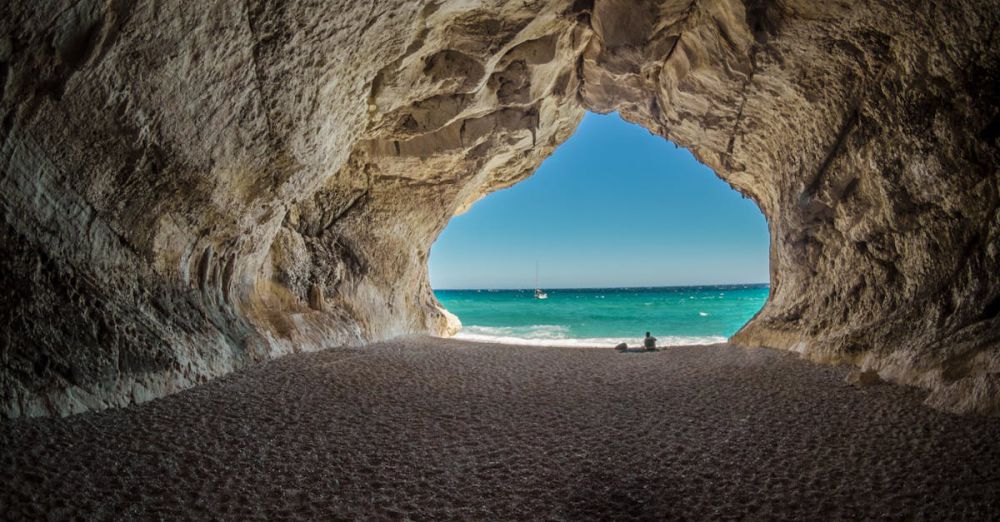 Beaches - Discover a peaceful beach scene framed by a natural cave formation, perfect for relaxation.