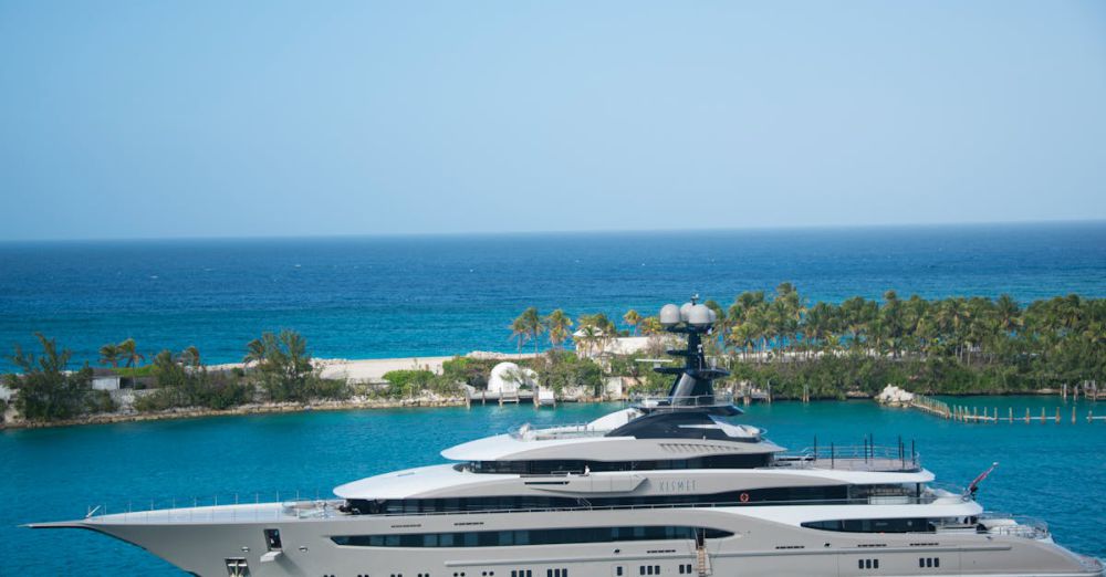 Luxury Yacht - High-end yacht cruising along a tropical coastline with clear blue waters and lush greenery.