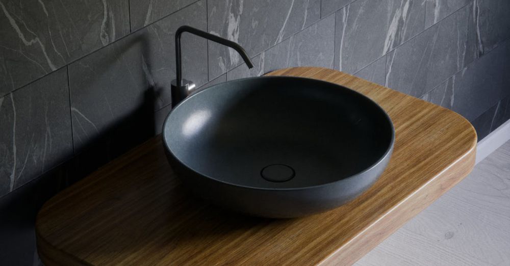 Luxury Furniture - Elegant gray bowl sink on wooden counter in a minimalist bathroom setting.