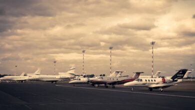 Private Jets - Line of private jets parked on the tarmac under a dramatic cloudy sky, showcasing aviation and travel.