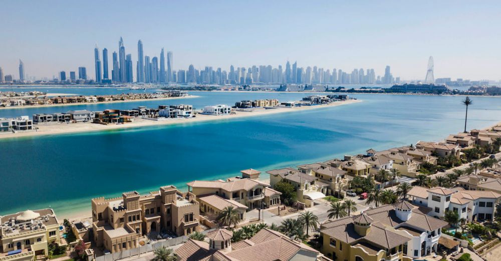 Luxury Resorts - A breathtaking aerial view of Dubai's skyscrapers and luxury villas on a sunny day.