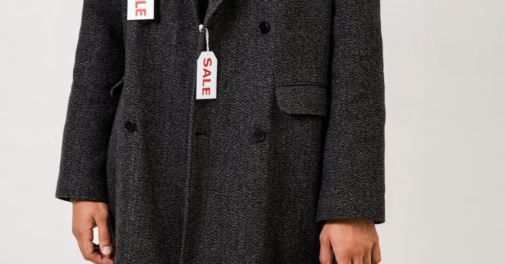 Discounts - A fashionable man holding shopping bags with sale tags on a chic winter coat, embracing holiday deals.